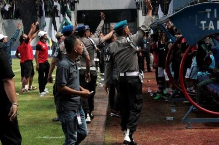 Petugas keamanan mencoba menenangkan suporter PSS Sleman yang melemparkan benda berupa botol ke bangku cadangan Persepam Madura Utama di Stadion Maguwoharjo, 2 Oktober 2016. 