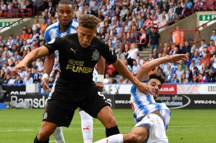 Aksi striker Newcastle United, Dwight Gayle (depan), dalam duel kontra Huddersfield di John Smith's Stadium, 20 Agustus 2017.