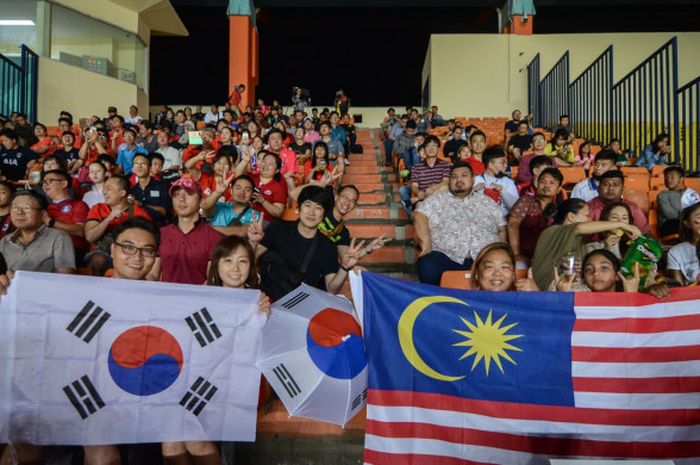 Pendukung timnas U-23 Malaysia dan timnas U-23 Korsel bersatu dalam satu tribune Stadion Si Jalak Harupat, Soreang, Kabupaten Bandung saat kedua tim berlaga pada sepak bola Asian Games 2018, Jumat (17/8/2018) malam. 