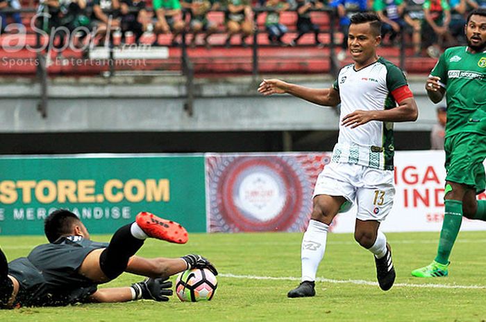 Kiper Persebaya Surabaya, Dimas Galih (kiri), menangkap bola sebelum sempat ditendang gelandang PS TNI Tira Bantul, Manahati Lestusen, paa hari pertama laga kedua Piala Presiden 2018 Grup C di Stadion Gelora Bung Tomo Surabaya, Jawa Timur, Kamis (18/01/2018) malam.