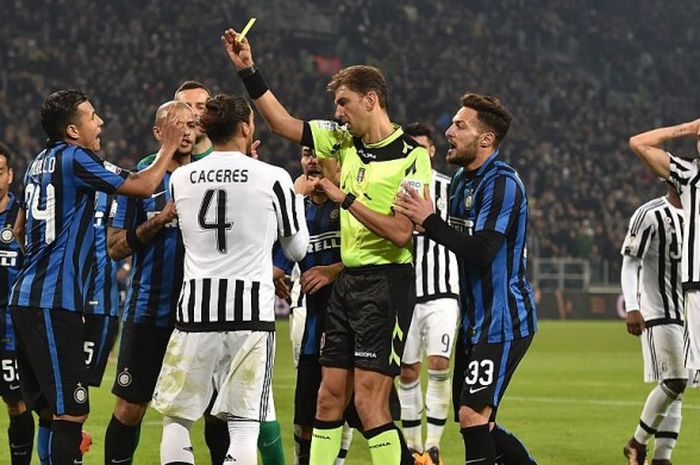 Wasit Paolo Tagliavento (tengah) mencabut kartu kuning buat bek Inter, Jeison Murillo, dalam duel Juventus versus Inter, 27 Januari 2016.
