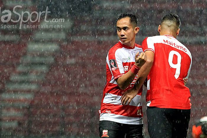 Playmaker Madura United, Slamet Nurcahyo (kiri), berpelukan dengan gelandang Raphael Maitimo, menjel