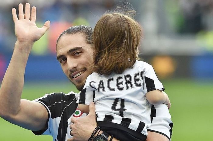 Bek Juventus, Martin Caceres, menggendong anak bungsu nya saat merayakan kemenangan timnya atas Sampdoria dalam laga lanjutan Serie A 2015-2016 di Stadion Juventus Arena, Turin, pada 14 Mei 2016.