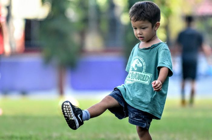Kenji Zizou Bachdim tengah asik berlatih melompati cone ditepi lapangan seperti yang dilakukan sang ayah Irfan Bachdim bersama tim Bali United saat berlatih fisik. 