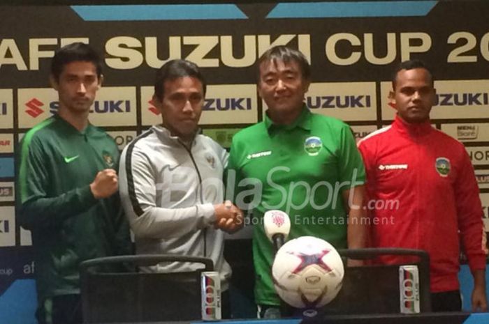 Pelatih timnas Indonesia, Bima Sakti, berjabat tangan dengan pelatih timnas Timor Leste, Norio Tsukitate saat sesi jumpa pers jelang laga melawan Timor Leste pada Piala AFF 2018 di SUGBK, Senin (12/11/2018).