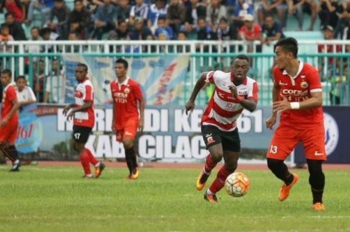 Bek Persija, Gunawan Dwi Cahyo (kanan) mencoba menjauhkan bola dari penyerang Madura United, Guy Junior pada laga Cilacap Cup 2017 di Stadion Wijayakusuma, Cilacap, Jumat (24/3/2017) sore. 