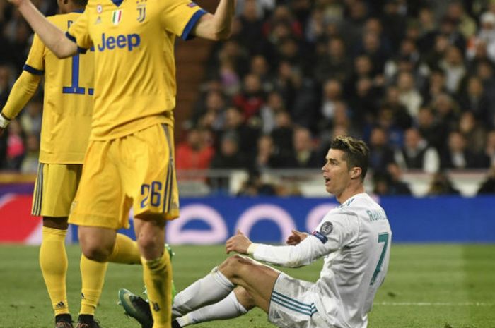  Penyerang Real Madrid, Cristiano Ronaldo, terjatuh seusai dijegal pemain Juventus dalam partai Lga Champions di Santiago Bernabeu, Rabu (11/4/2018) 