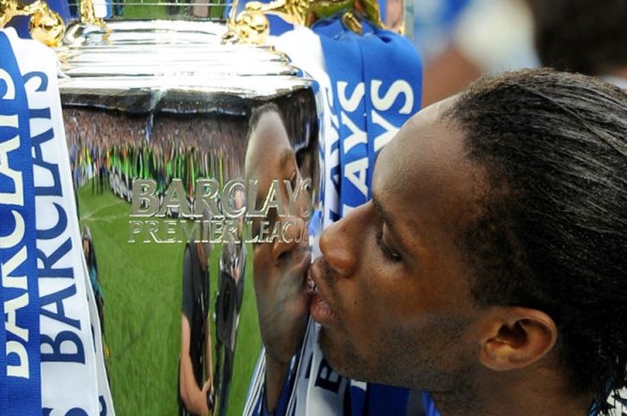 Striker Chelsea, Didier Drogba, mencium trofi Liga Inggris seusai timnya memenangi laga kontra Wigan Athletic di Stadion Stamford Bridge, London, pada 9 Mei 2010.