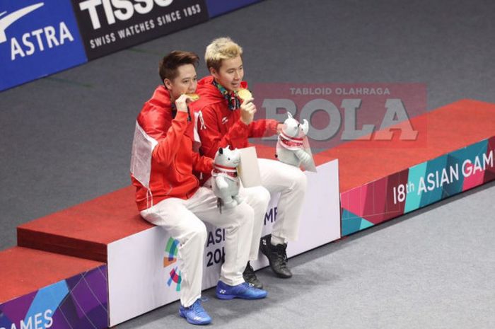  Marcus Fernaldi Gideon (kanan) dan Kevin Sanjaya Sukamuljo (kiri) memegang medali emas usai menjuarai cabang bulu tangkis nomor ganda putra Asian Games 2018, Selasa (28/8/2018). 