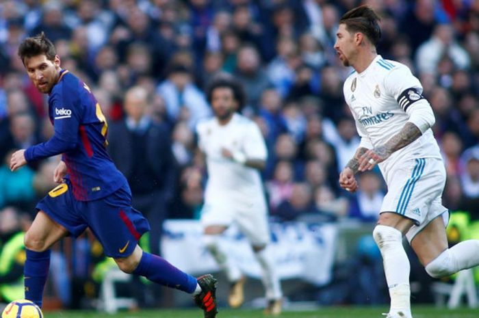 Megabintang FC Barcelona, Lionel Messi (kiri), berduel dengan bek Real Madrid, Sergio Ramos, dalam laga Liga Spanyol di Stadion Santiago Bernabeu, Madrid, pada 23 Desember 2017.