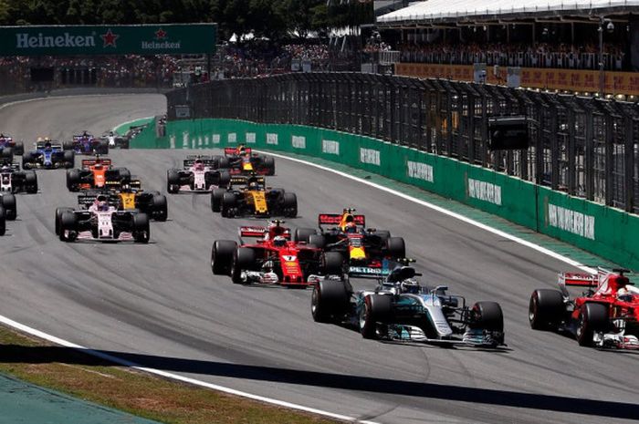  Sebastian Vettel (merah) merebut posisi terdepan dari Valtteri Bottas (abu-abu) selepas start balapan F1 GP Brasil yang berlangsung di Sirkuit Jose Carlos Pace, Sao Paulo, Brazil (12/11/2017).   