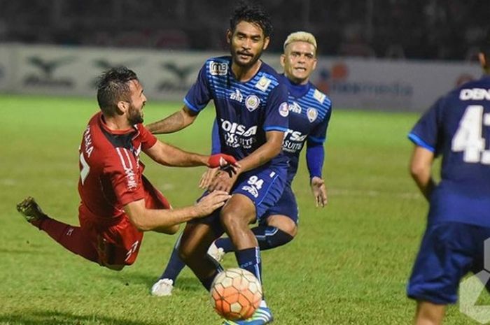 Gelandang Arema Cronus, Ferry Aman Saragih, berjibaku dengan gelandang impor Semen Padang asal Bosnia-Herzegovina, Muamer Svraka, pada laga yang mempertemukan kedua tim di Stadion H Agus Salim, Padang, Jumat (28/10/2016).