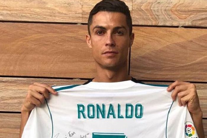 Cristiano Ronaldo memegang jersey untuk Santiago Flores