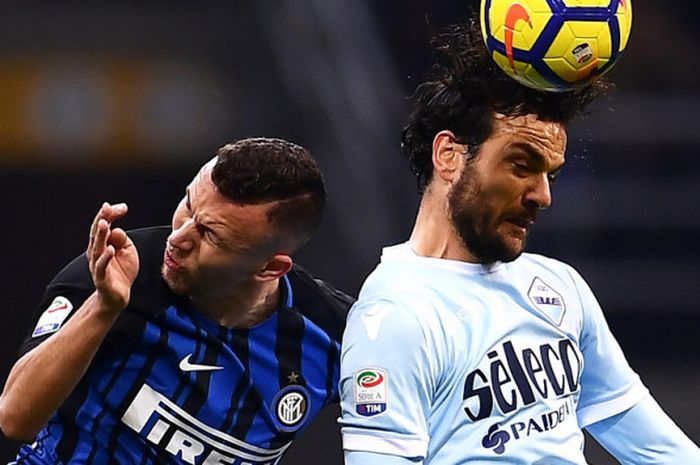 Aksi gelandang Inter Milan, Ivan Perisic (kiri), saat berduel dengan pemain Lazio, Marco Parolo, dalam pertandingan Liga Italia 2017-2018 di Stadion Giuseppe Meazza, Milan, Italia, pada Sabtu (30/12/2017).