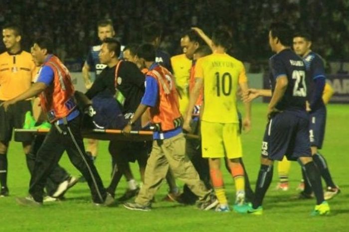 Petugas medis mengangkat gelandang Arema, Marcio Teruel yang mengalami cedera saat timnya dijamu Persegres Gresik United di Stadion Tri Dharma, Jumat (7/10/2016) malam.