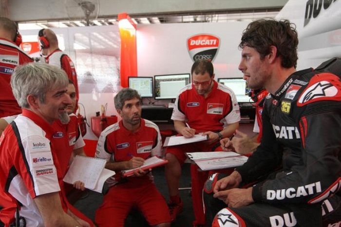 Pebalap asal Inggris, Cal Crutchlow (kanan) berbincang dengan manajer tim, Gigi Dall'Igna (kiri) saat menjalani tes pramusim MotoGP 2014 bersama tim Ducati.