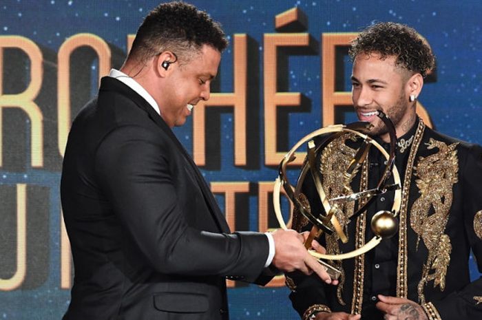 Penyerang Paris Saint-Germain, Neymar (kanan), tersenyum saat menerima penghargaan sebagai Pemain Terbaik Liga Prancis 2017-2018 dari UNFP yang diberikan oleh seniornya, Ronaldo Luis da Lima, di Prancis pada Minggu (13/5/2018).