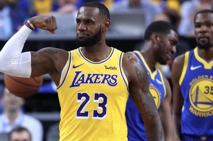 Selebrasi LeBron James (jersey kuning) saat memperkuat LA Lakers melawan Golden State Warriors pada laga pramusim NBA yang berlangsung Kamis (11/10/2018) WIB.