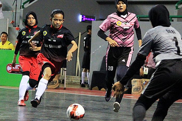 Pemain putri Universitas Sriwijaya (kiri), berupaya melewati hadangan pemain AMIK Bina Sriwijaya pada laga Pul X  LIMA Futsal: Go-Jek Sumatra Conference (SMC) 2018 di GOR Dempo, Jakabaring Sport City, Palembang, Rabu (17/10/2018).