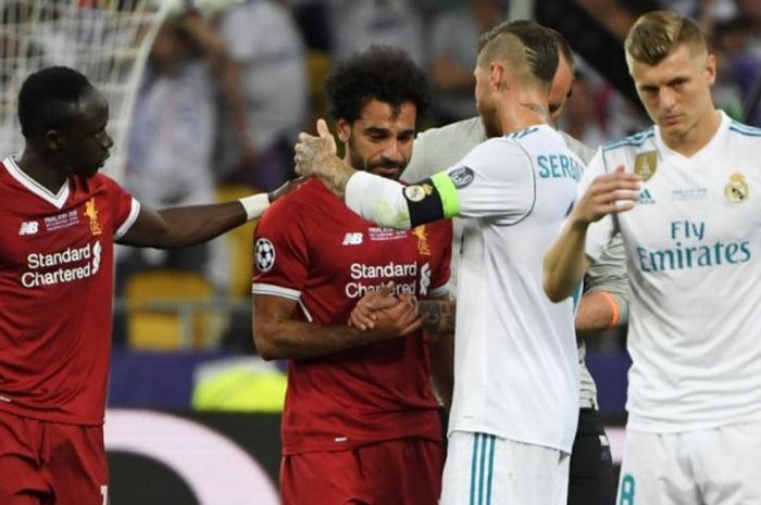 Striker Liverpool, Mohamed Salah (dua dari kiri), dihibur oleh bek Real Madrid, Sergio Ramos, setelah mengalami cedera dan harus ditarik keluar lebih dini dalam laga final Liga Champions di Stadion NSC Olimpiyskiy, Kiev, Ukraina pada 26 Mei 2018.