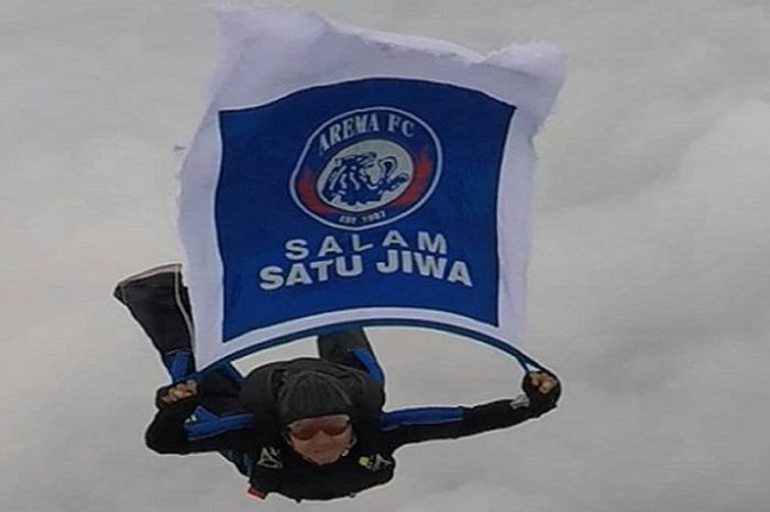 Arema DEJANKA (Detasemen Jala Mangkara), membentangkan bendera untuk Arema FC di lautan awan.