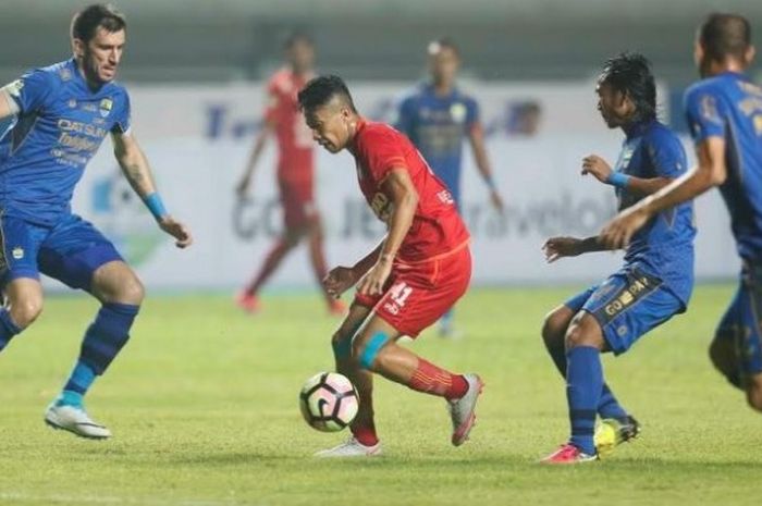 Tiga pemain Persib, Vladimir Vujovic (kiri), Hariono, dan Supardi Nasir (kanan) mengawasi pergerakan gelandang Arema FC, Dendi Santoso pada laga pekan pertama Liga 1 musim 2017 di Stadion GBLA, Kota Bandung, 15 April 2017. 