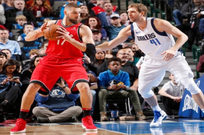 Pemain kawakan Dallas Mavericks, Dirk Nowitzki (jersey putih #41) saat menjaga pemain Toronto Raptors, Jonas Valanciunas dalam lanjutan laga NBA 2017-2018, Selasa (26/12/2017) waktu Amerika Serikat.