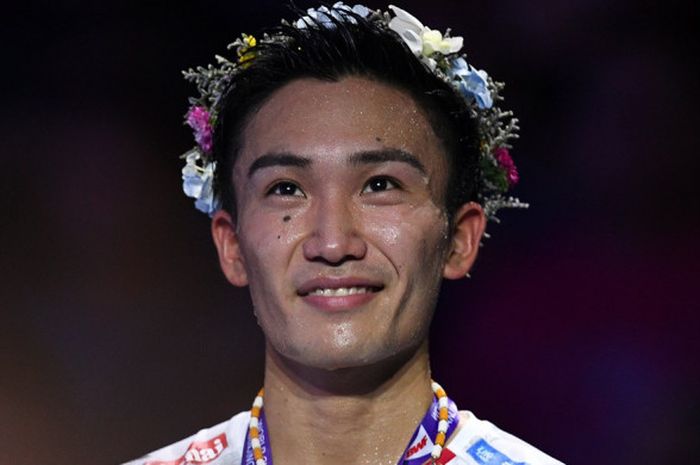       Pebulu tangkis tunggal putra Jepang, Kento Momota, tersenyum di atas podium kampiun Kejuaraan Dunia 2018. Momota meraih gelar juara dunia tahun ini setelah mengalahkan Shi Yuqi (China) 21-11, 21-13 pada laga final yang berlangsung di Nanjing Olympic Sports Centre, Nanjing, China, Minggu (5/8/2018).      