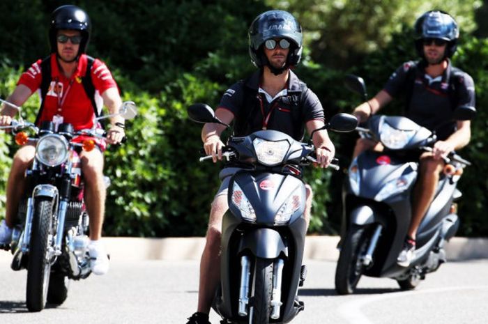Sebastian Vettel dan Romain Grosjean terpaksa naik motor untuk menerobos kemacetan di sekitar Sirkuit Paul Ricard, Prancis.