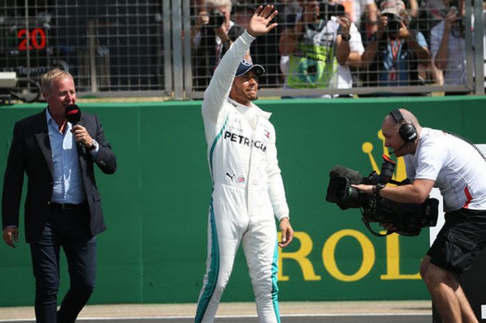 Lewis Hamilton melambaikan tangan usai meraih pole position saat kualifikasi GP Inggris di Sirkuit Silverstone, Inggris, Sabtu (7/7/2018).