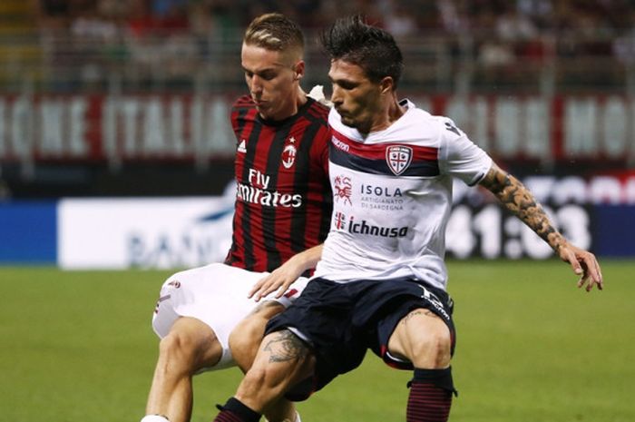 Bek AC Milan, Andrea Conti (kiri), berduel dengan pemain Cagliari, Fabio Pisacane, dalam laga Liga Italia di Stadion San Siro, Milan, pada 27 Agustus 2017.