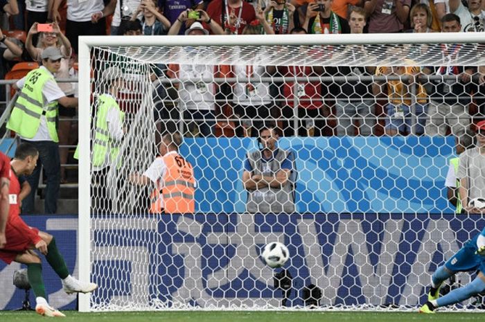 Kiper Iran, Alireza Beiranvand, menepis tendangan penalti megabintang Portugal, Cristiano Ronaldo, d