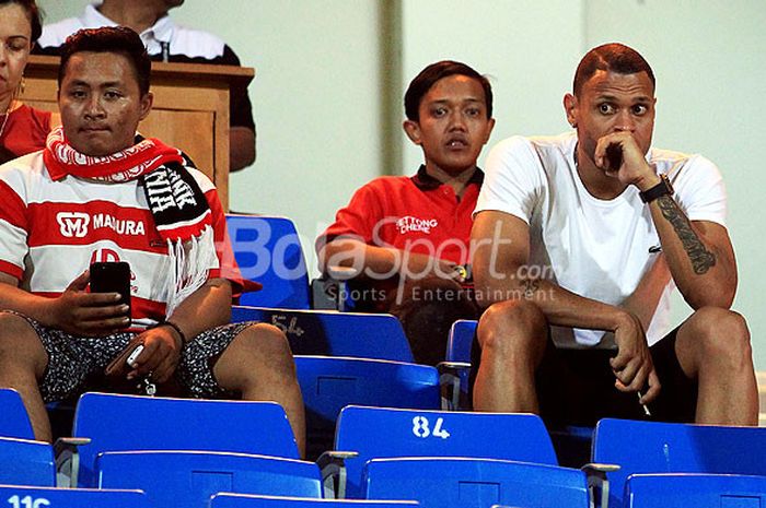 Pemain asing Perseru Serui, Luiz Junior (kanan), menyaksikan laga pekan ke-16 Liga 1 2018 antara Madura United melawan Perseru Serui dari bangku tribun penonton Stadion Ratu Pamellingan Pamekasan, Jawa Timur, pada Selasa (16/07/2018) malam