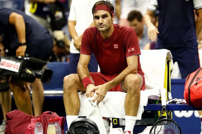 Petenis tunggal putra Swiss, Roger Federer, berusaha mendinginkan suhu tubuhnya dengan menggunakan kipas angin kecil d sela pertandingan babak 16 besar US Open 2018 yang berlangsung di Flushing Meadows, New York, Amerika Serikat, Senin (3/9/2018) waktu setempat.