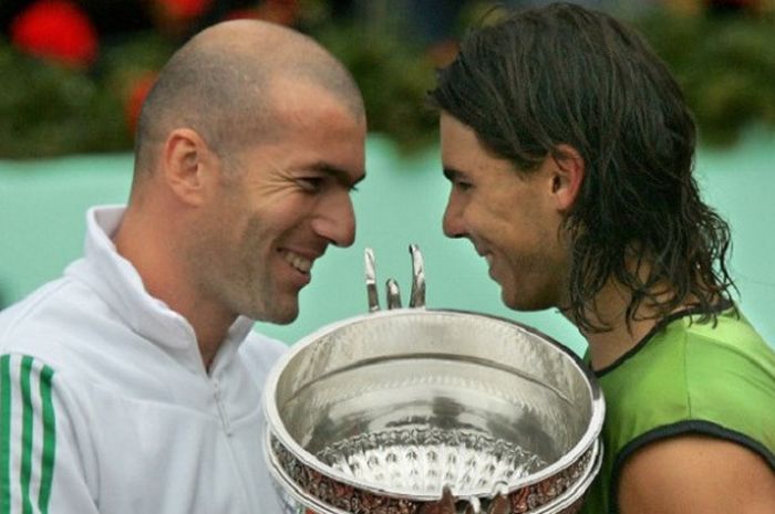 Zinedine Zidane saat memberikan trofi Roland Garros kepada Rafael Nadal (kanan) seusai laga final tunggal putra yang berlangsung pada 5 Juni 2005.