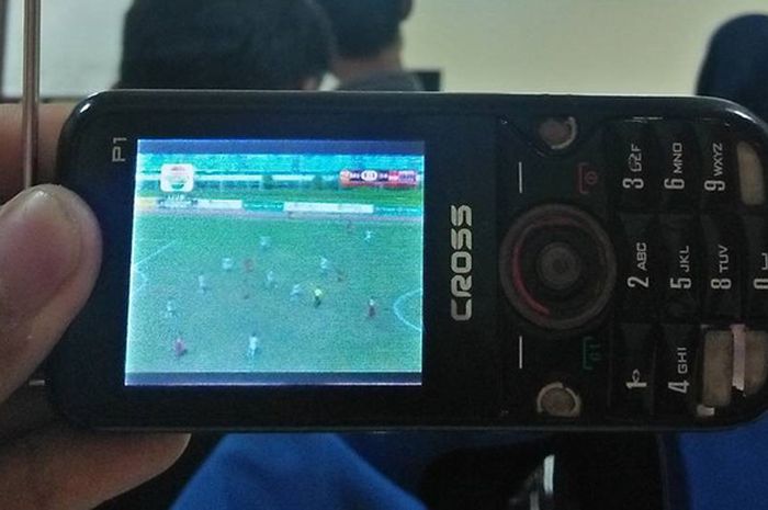Seorang netizen menyaksikan laga Indonesia vs Brunei  di ajang Piala AFF u-18 melalui gawai miliknya, Rabu (13/9/2017)