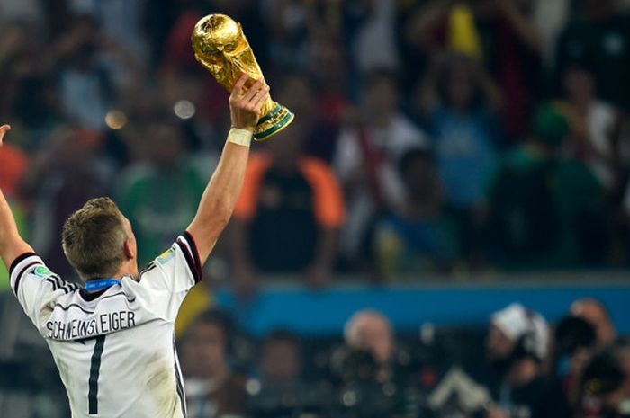  Gelandang Jerman, Bastian Schweinsteiger, mengangkat trofi Piala Dunia setelah mengalahkan Argentina dalam partai final di Stadion Maracana, Rio de Janeiro, Brasil, pada 13 Juli 2014. 