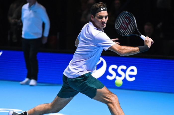 Petenis Swiss, Roger Federer, mengembalikan bola pukulan dari Andy Murray, pada laga tenis ekshibisi amal bertajuk 