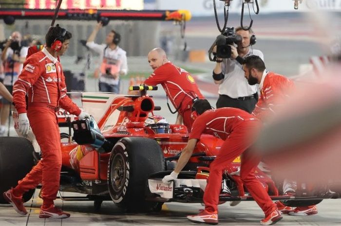 Pebalap Ferrari, Kimi Raikkonen, memasuki garasi timnya saat menjalani sesi latihan bebas GP Bahrain di Sirkuit Internasional Bahrain, Sakhir, Jumat (14/4/2017). 