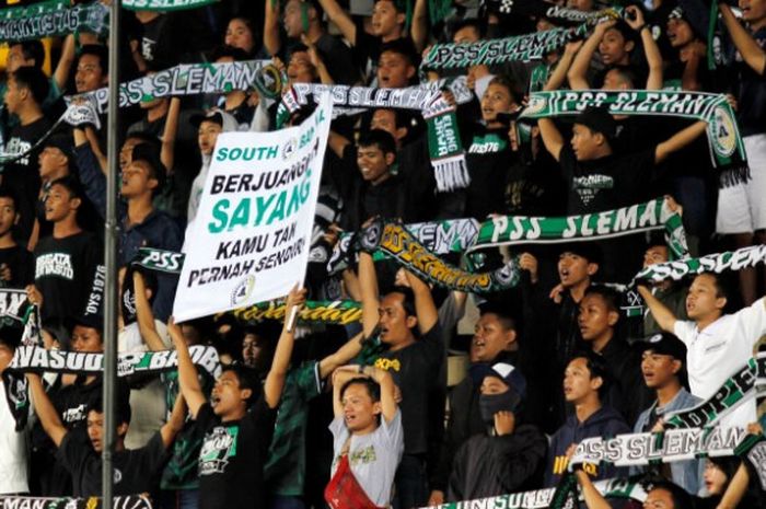  Suporter PSS Sleman beraksi saat mendukung tim idolanya bertanding di Stadion Maguwoharjo, Sleman.  