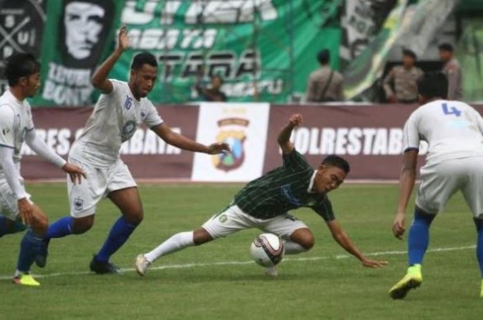 Pemain sayap Persebaya, Rendi Irwan di antara tiga pemain PSIS Semarang pada uji coba di Stadion Gelora Bung Tomo, Surabaya, Minggu (19/3/2017) sore. 