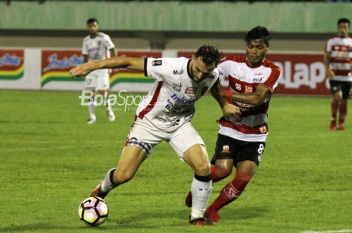 Striker Bali United, Ilija Spasojevic, berduel dengan pemain Madura United, Alftah Faathier, pada babak perempat final Piala Presiden 2018, di Stadion Manahan, Solo, Sabtu (3/2/2018).