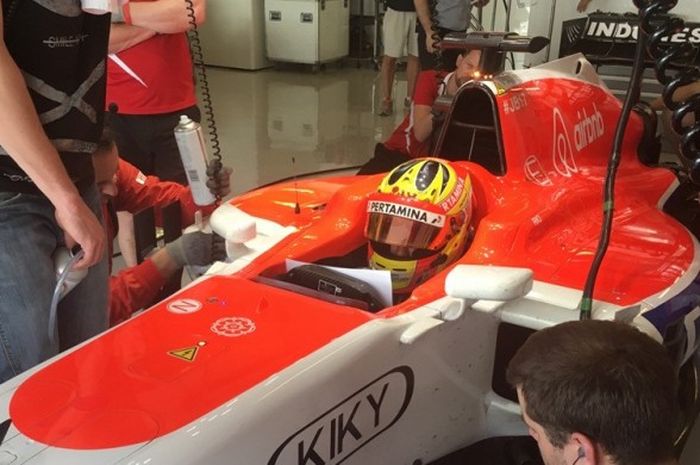 Pebalap Indonesia, Rio Haryanto, bersiap di paddock tim Manor tes Formula 1 di Sirkuit Yas Marina, Abu Dhabi, Selasa (1/12/2015).