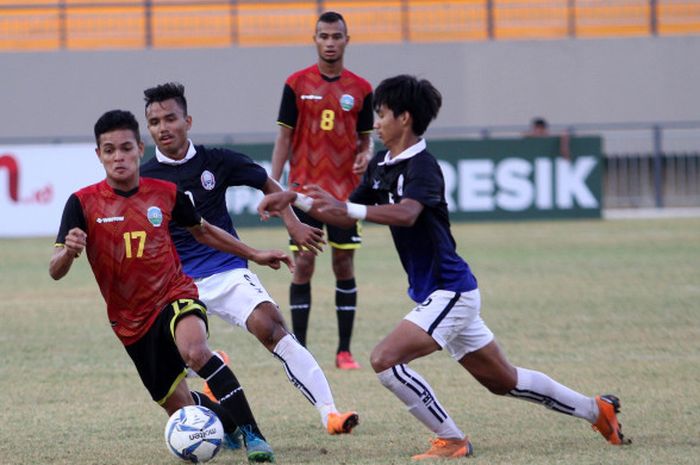 Pemain Timnas U-19 Timor Leste, Paulo C. Gali Da Costa Freitas (17), berusaha melewati dua pemain Kamboja pada laga terakhir grup B di Stadion Gelora Joko Samudro, Selasa (10/7/2018).