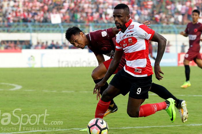 Striker Madura United, Greg Nwokolo, menggiring bola melewati pemain PSM Makassar dalam laga lanjutan pekan ke-17 Liga 1 di Satdion Gelora Bangkalan, Jawa Timur, Sabtu (29/07/2017) sore.