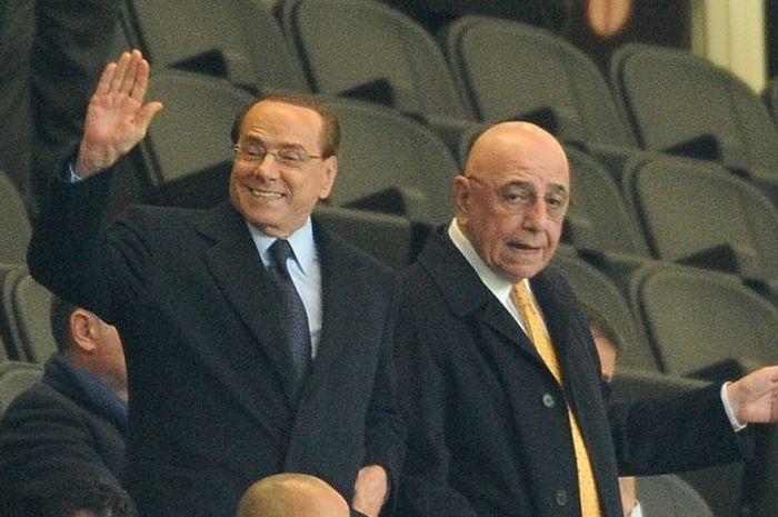 Presiden AC Milan, Silvio Berlusconi (kiri) bersama wakilnya, Adriano Galliani, saat menyaksikan laga kontra Inter dalam ajang Trofeo Berlusconi di tribune Giuseppe Meazza, 21 Oktober 2015.