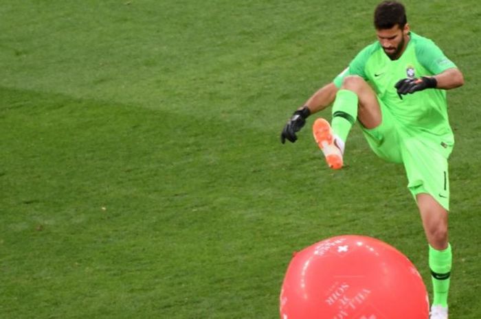 Kiper Brasil, Alisson Becker, memecahkan balon yang memasuki lapangan saat laga fase grup Piala Dunia 2018 kontra Swiss di Rostov Arena, 17 Juni 2018.