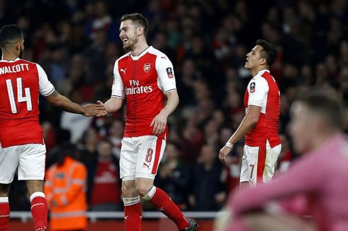 Gelandang Arsenal, Aaron Ramsey (kedua dari kiri) merayakan gol bersama rekan setimnya, Theo Walcott (kiri), seusai mencetak gol ke gawang Lincoln City dalam laga babak perempat final Piala FA di Stadion Emirates, London, pada 11 Maret 2017.