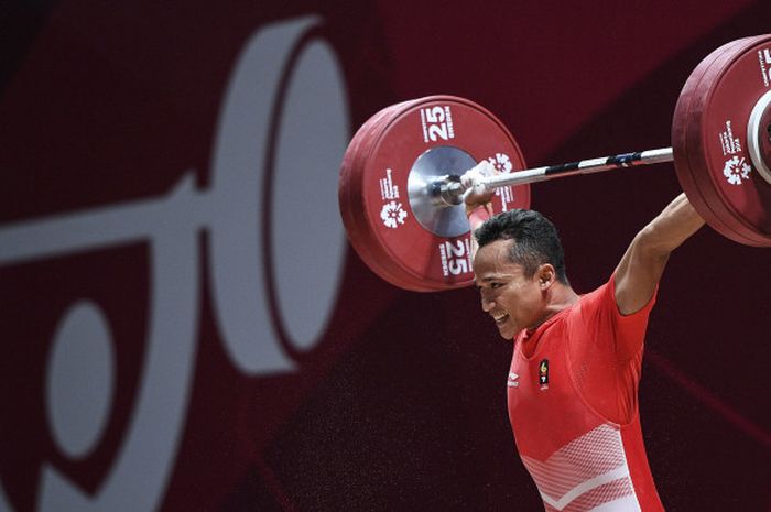 Atlet angkat besi Indonesia, Triyatno, saat melakukan angkatan pada nomor 65 kg putra Asian Games 2018.