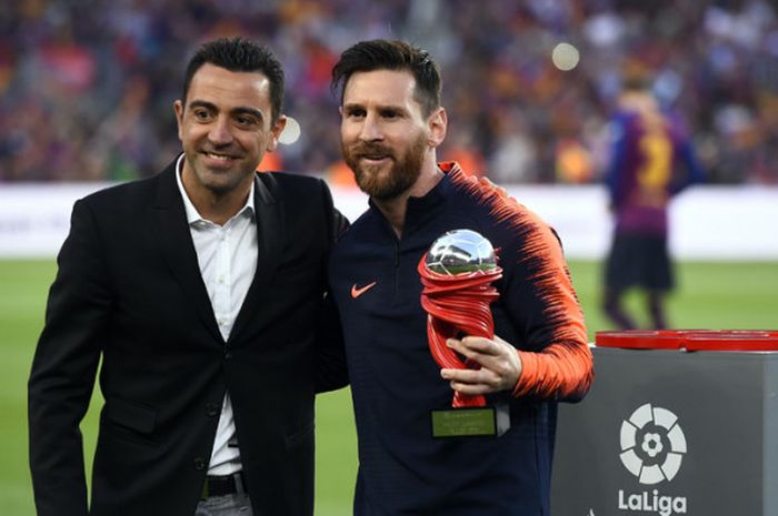 Xavi Hernandez (kiri) berpose bersama Lionel Messi yang menerima trofi Pemain Terbaik Bulan Ini menjelang laga FC Barcelona vs Real Sociedad di Stadion Camp Nou, 20 Mei 2018.